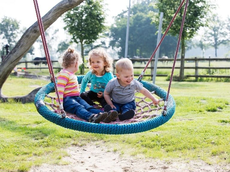 Kinder auf Nestschaukel