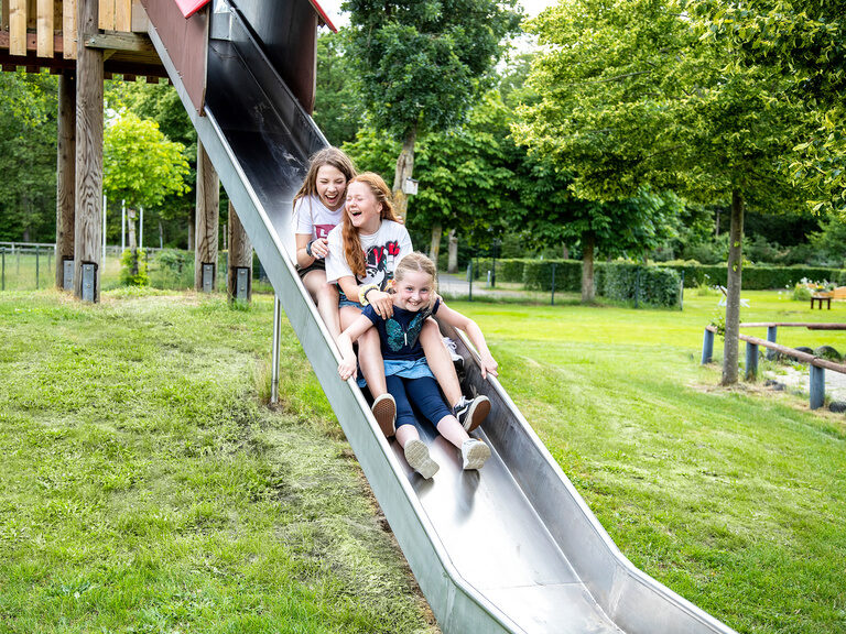 Familienhotel Landhus Laurenz im Münsterland: 3 Mädchen rutschen auf Rutsche runter