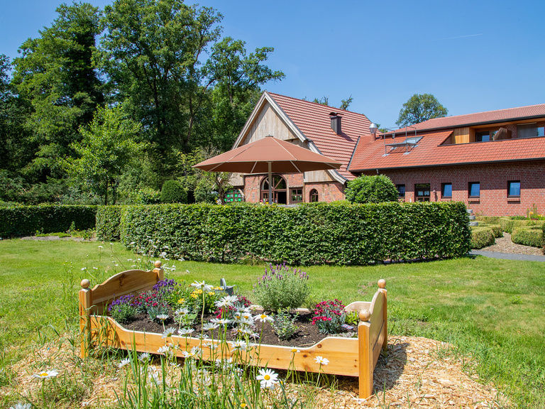 Familienhotel Landhus Laurenz im Münsterland: Hotel Außenansicht mit Garten und kleinem Blumenbeet