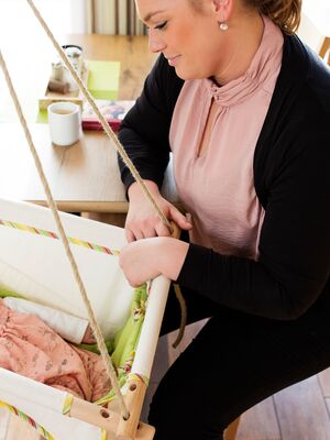 Frau mit Säugling in Schaukel